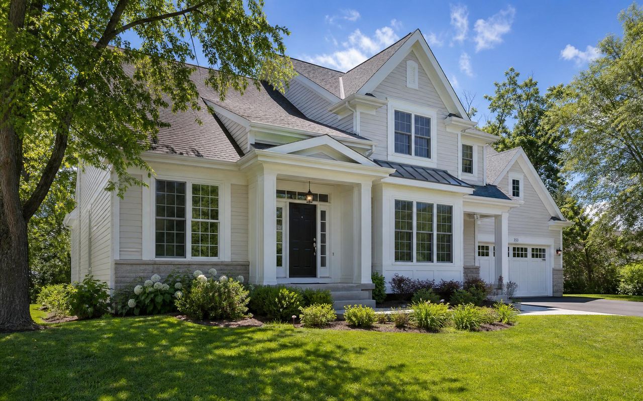 Traditional suburban home exterior in Northern Illinois with siding, windows, roofing, and entry door